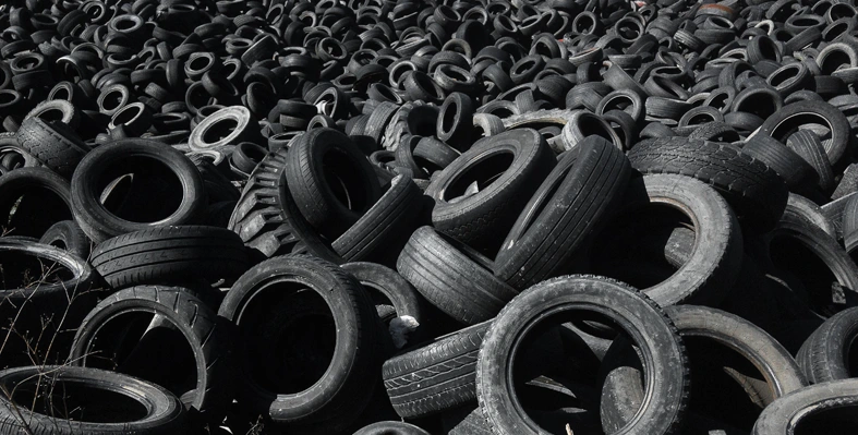 A pile of old tyres discarded in a field.