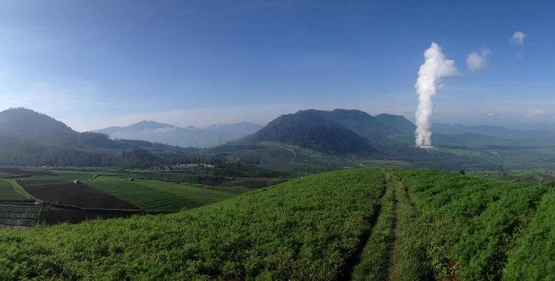 A landscape with geothermal steam in the distance. 