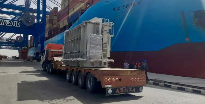 The transformer being transported on the back of a truck having just been removed from a ship.