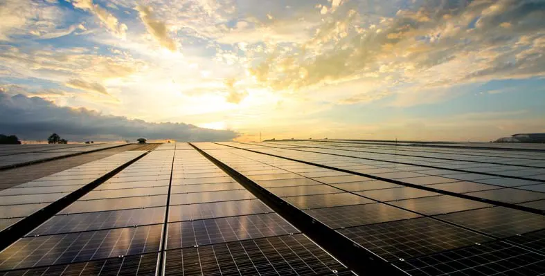 Solar panels against a bright sunset