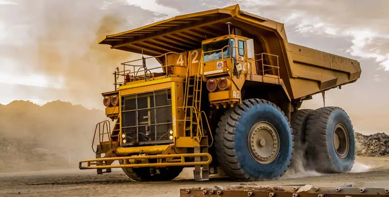 Large mining quarry machinery driving on site.