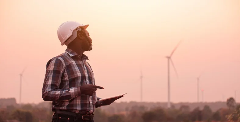 An industrial engineering surveying a wind farm. 