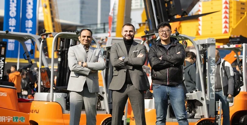 Leaders of Mycrane posing for a picture in front of cranes