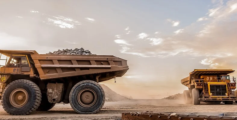 Two mining trucks working on a site. 