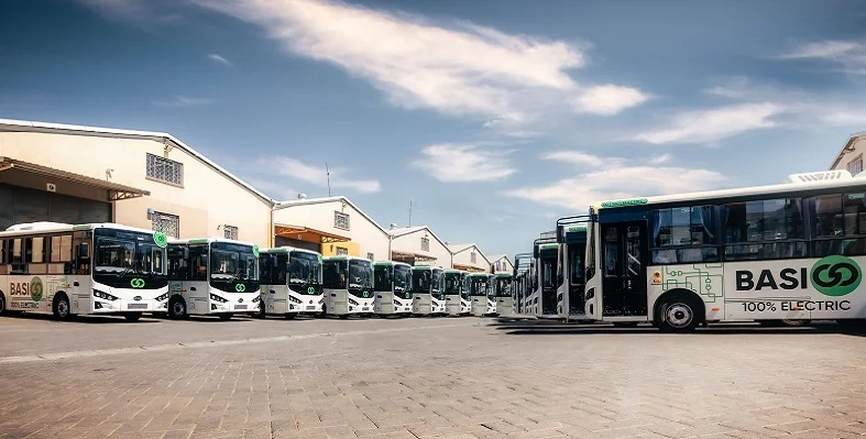 Several BasiGo electric buses lined up in a car park