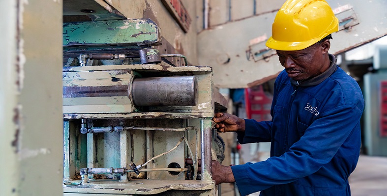 A Benin worker manning a machine in a textile factory.