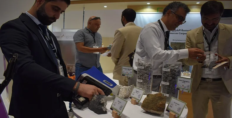 A visitor of The Mining Show holding a device up to a piece of ore. 