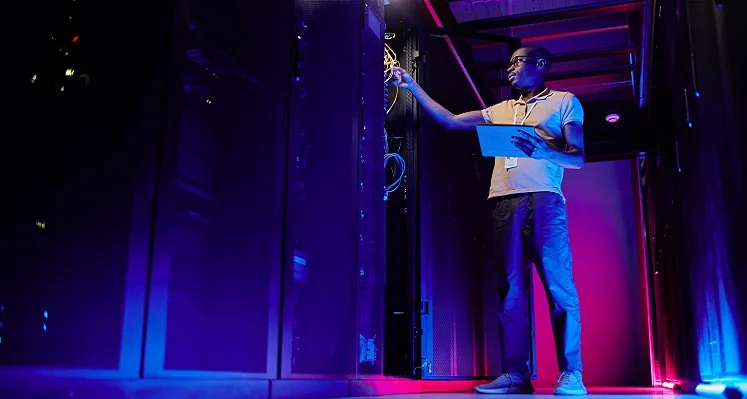 A technician working on a piece of equipment in a data centre. 