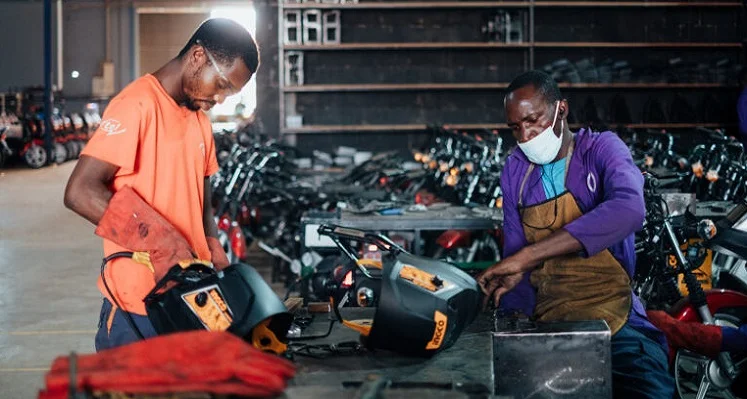 Two engineers in Uganda working on electric motocylces.