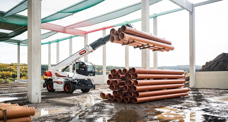 A new rotary telehandler from Bobcat lifting pipes on a construction site.