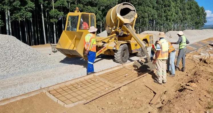 Workers operating a Carmix static mixer and pouring concrete as part of a construction project.