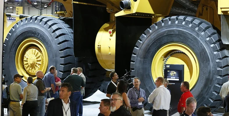 MINExpo attendees standing in front of a large mining haul truck.