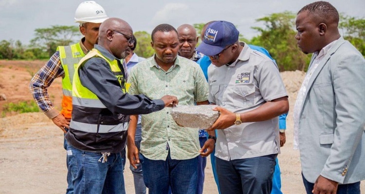 The Lindi Jumbo manager showing large graphite flakes to Anthony Mavunde.